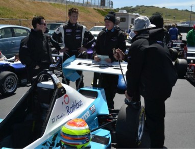 Post race talk at the famed Mazda Raceway Laguna Seca in Monterey, CA.  Jeff Andretti (Coach) in glasses.  Eric Purcell- Engineer in Duck Hat, JJ Ho, mechanic, with foot on tire