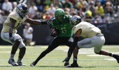 Nelson makes a move on two defenders during the Oregon spring game.