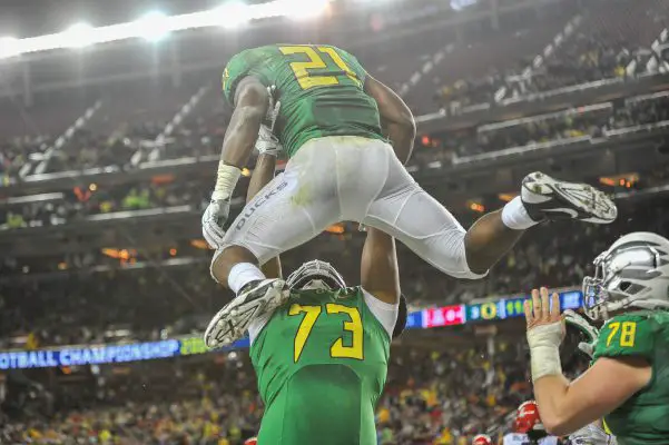 Crosby hoisting star running back Royce Freeman into the air after a touchdown in the Pac-12 championship game.
