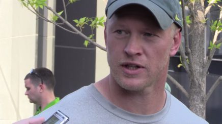 Scott Frost talks to reports after practice