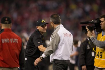 Coach Helfrich greeting Coach Meyer at the National Championship Game