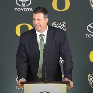 Hollywood, CA. 25th July, 2018. Oregon quarterback Justin Herbert answers  questions as head coach Mario Cristobal looks on at the Pac-12 football  media day on Wednesday, July 25, 2018 at the Hollywood