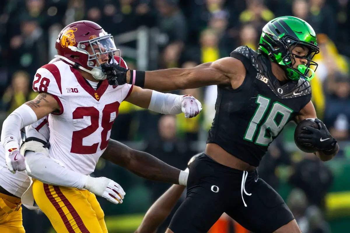 Oregon tight end Kenyon Sadiq stiff-arms a USC defender en route to the end zone last Saturday in Eugene. Photo by Max Unkrich